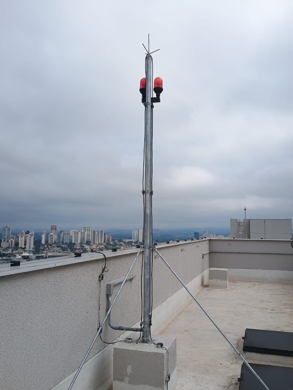 Mastro de captação com luzes de balizamento em cobertura de edifício residencial